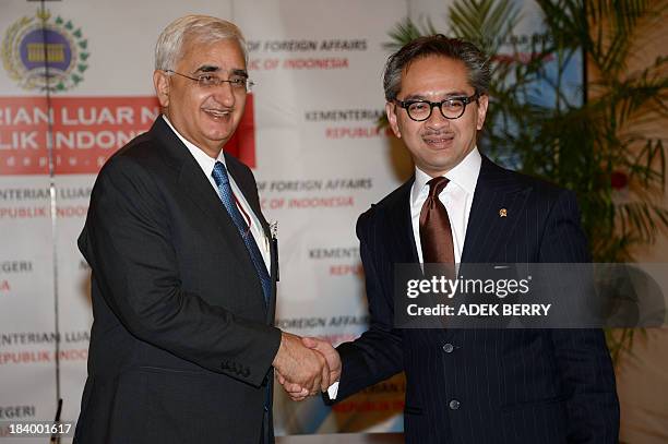 Indian Foreign Minisiter Salman Khurshid shakes hand with Indonesia's Foreign Minister Marty Natalegawa prior to a meeting in Jakarta on October 11,...