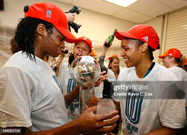 Devereaux Peters, Seimone Augustus and Maya Moore of the Minnesota Lynx celebrate with the trophy after their 86-77 win over the Atlanta Dream in...