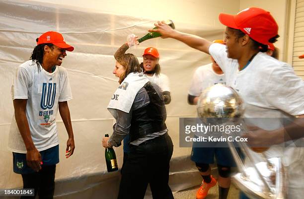Seimone Augustus and Maya Moore douse champagne on head coach Cheryl Reeve of the Minnesota Lynx as they celebrate their 86-77 win over the Atlanta...