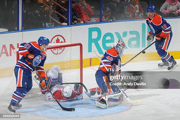 Andrew Ference, Devan Dubnyk and Justin Schultz of the Edmonton Oilers defend as Brendan Gallagher of the Montreal Canadiens crashes into the net on...