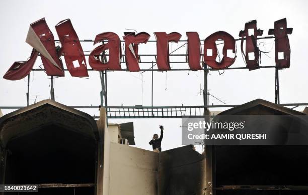 Pakistani rescue worker stands on the roof of the devastated Marriott Hotel in Islamabad on September 21 following an overnight suicide bomb attack....