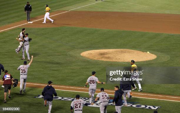 Joaquin Benoit and Alex Avila of the Detroit Tigers is congratulated by teammates including Justin Verlander after they beat the Oakland Athletics in...