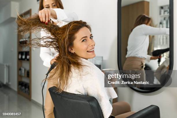 hairdresser creates glamour while client sips a latte - beauty spa stockfoto's en -beelden