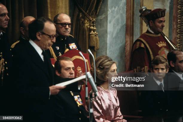 King Juan Carlos and Queen Sofia of Spain listen as Parliamentary President Antonio Hernandez-Gil addresses the Spanish parliament after the signing...