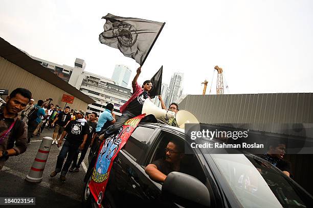 Protester holds a flag bearing the logo of Malaysian Youth Solidarity Movement during a protest against Trans Pacific Partnership Agreement outside...