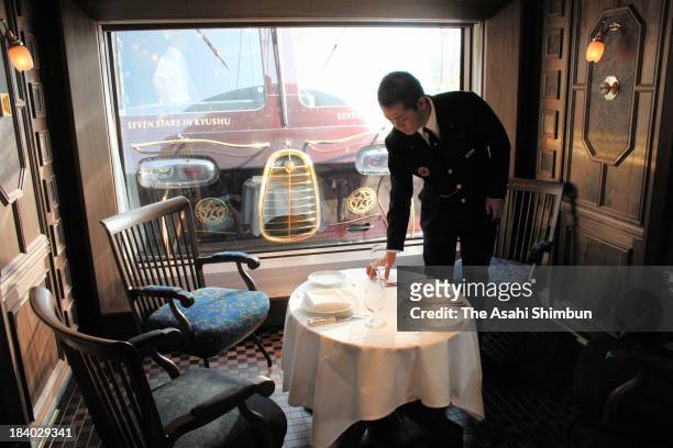 Train attendant practices table setting during the press preview of 'Nanatsuboshi ' luxury sleeper cruise train on October 10, 2013 in Kagoshima,...