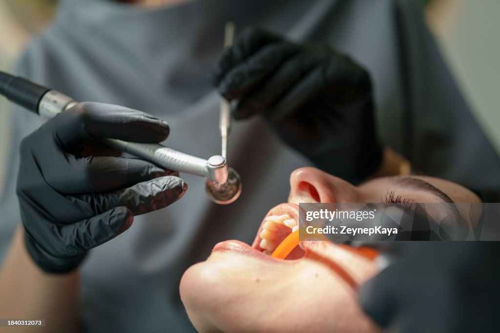 Close up to patient mouth with dental tools