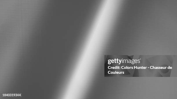 black and white close-up of a textured and wavy plastic tarpaulin with a ray of light in paris, france - gewelltes material stock-fotos und bilder