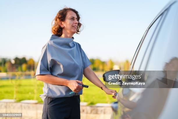 healthcare worker holding car keys next to automobile, after work - showus doctor stock pictures, royalty-free photos & images