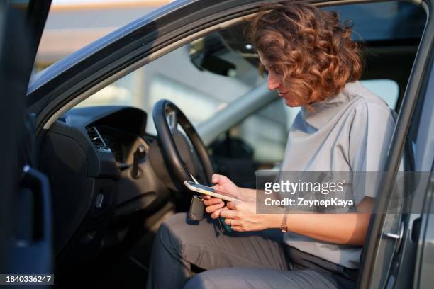 healthcare workers using mobile phone in her car, after work - showus doctor stock pictures, royalty-free photos & images