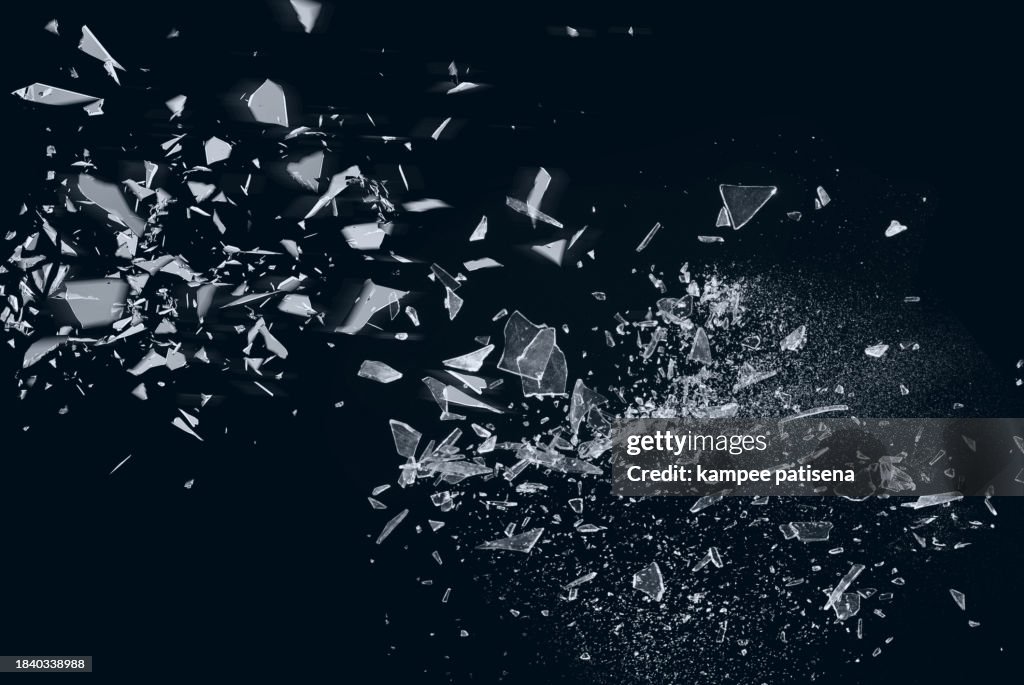 Broken Glass on Black Background shows the abstract texture of the shattered glass in great detail. The image is perfect for use in backgrounds, textures, or abstract art projects.