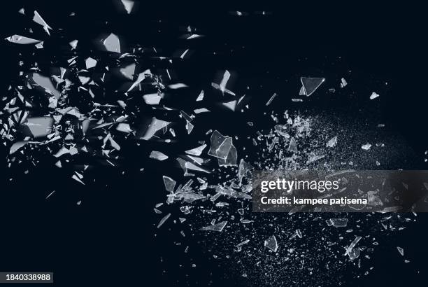 broken glass on black background shows the abstract texture of the shattered glass in great detail. the image is perfect for use in backgrounds, textures, or abstract art projects. - broken glass pieces stock pictures, royalty-free photos & images
