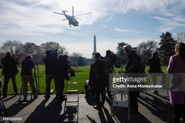 Reporters watch as Marine One, carrying U.S. President Joe Biden, departs from the White House on December 08, 2023 in Washington, DC. Biden is...