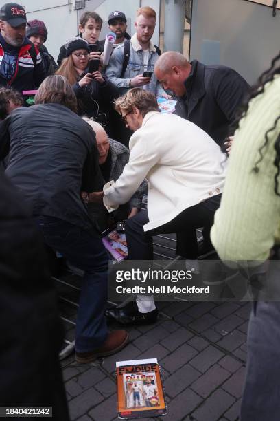 Ryan Gosling helps up a fan after a barrier falls as he arrives at BFI Southbank for an 'In Conversation about Barbie' event on December 08, 2023 in...