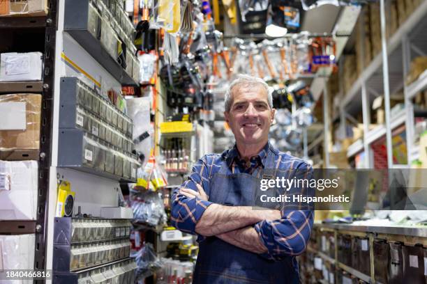 happy business owner working at a hardware store - loja de ferragens imagens e fotografias de stock