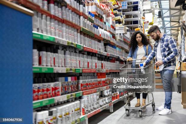 paar kauft farbe in einem baumarkt - baumarkt stock-fotos und bilder