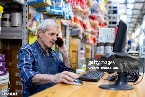 business owner at a hardware store taking an order on the phone - worktop imagens e fotografias de stock