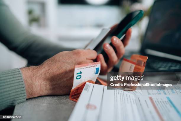 mid adult man takes control of his finances with mobile bill pay - loonbrief stockfoto's en -beelden