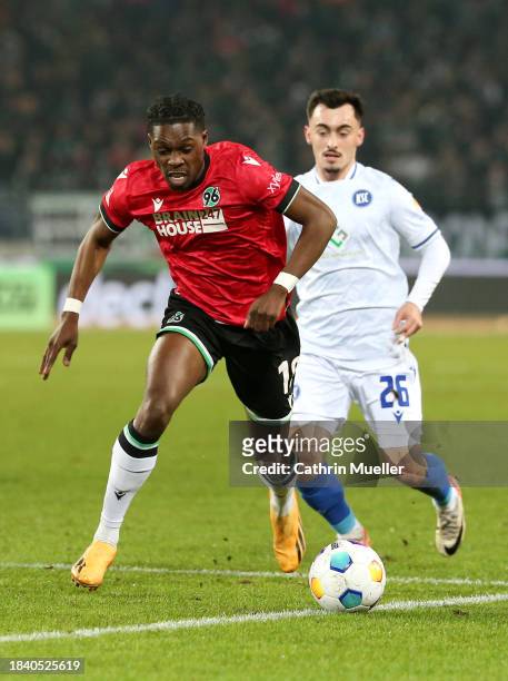 Derrick Koehn of Hannover 96 runs with the ball whilst under pressure from Paul Nebel of Karlsruher SC during the Second Bundesliga match between...