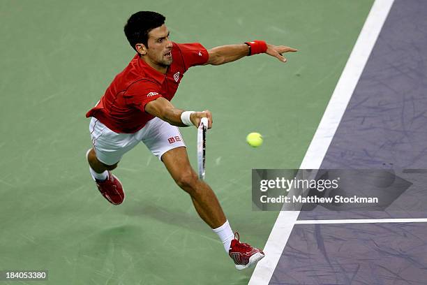 Novak Djokovic of Serbia lunges for a ball while playing Gael Monfils of France during the Shanghai Rolex Masters at the Qi Zhong Tennis Center on...