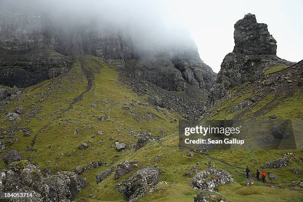 Visitors hike under rock formations known as Old Man Storr on October 5, 2013 near Portree, Isle of Skye, Scotland. The Isle of Skye is a popular...