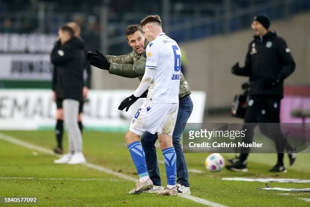 Christian Eichner, Head Coach of Karlsruher SC, speaks with his player Leon Jensen during the Second Bundesliga match between Hannover 96 and...