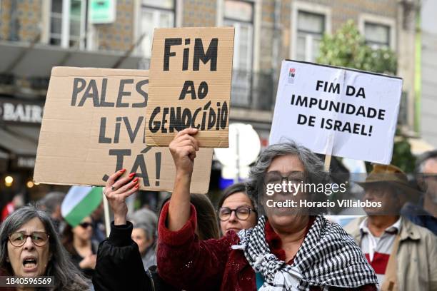 Demonstrators hold signs as they march from Martim Moniz Square to Largo Jose Saramago during a protest organized by the Portuguese Council for Peace...