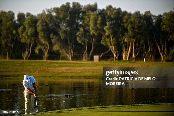 Chilean golfer Felipe Aguilar putts on the 11th hole during the second day of the Portugal Masters golf tournament at Victoria Golf Course in...