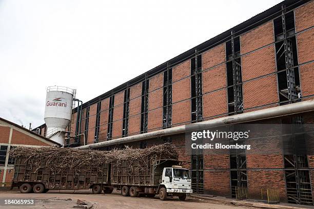 Trucks loaded with sugarcane plants enter the mill at Unidade Industrial Cruz Alta da Guarani SA's processing plant, near Sao Jose do Rio Preto,...