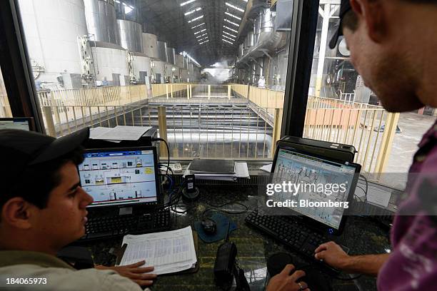 Workers speak in a control room at Unidade Industrial Cruz Alta da Guarani SA's sugar processing plant, near Sao Jose do Rio Preto, Brazil, on...