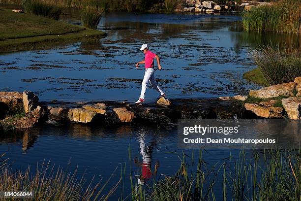 Tommy Fleetwood of England uses some stepping stones to cross the water from the 17th tee to the 16th green during the second round of the Portugal...