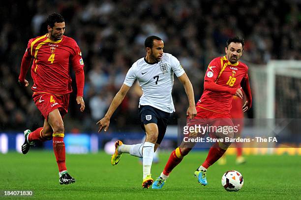 Andros Townsend of England is pursued by Milan Jovanovic and Nikola Drincic of Montenegro during the FIFA 2014 World Cup Qualifying Group H match...