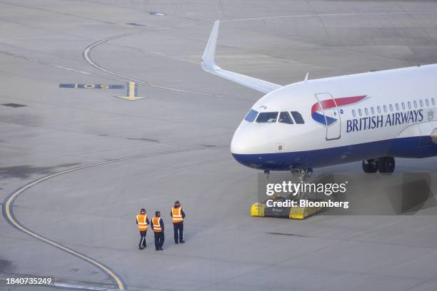 Ground staff near a passenger aircraft, operated by British Airways Plc, at Heathrow Airport Terminal 5, in London, UK, on Monday, Dec. 11, 2023....