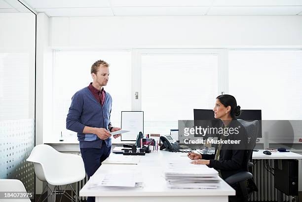 Two coworkers in discussion in an office