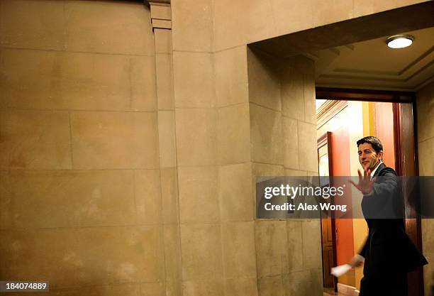 House Budget Committee Chairman Rep. Paul Ryan waves to photographers as he walks towards to the office of Speaker of the House Rep. John Boehner at...