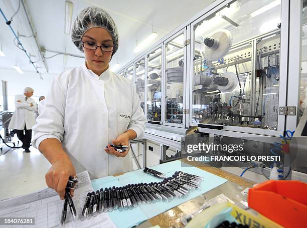 An employee works on pencils to make up on October 11, 2013 at the Alkos Cosmetique factory in Boulogne-sur-Mer. AFP PHOTO FRANCOIS LO PRESTI