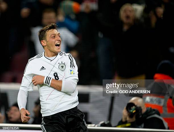 Germany's midfielder Mesut Ozil celebrates scoring his side's 3rd goal during the FIFA 2014 World Cup Group C qualifying football match Germany vs...