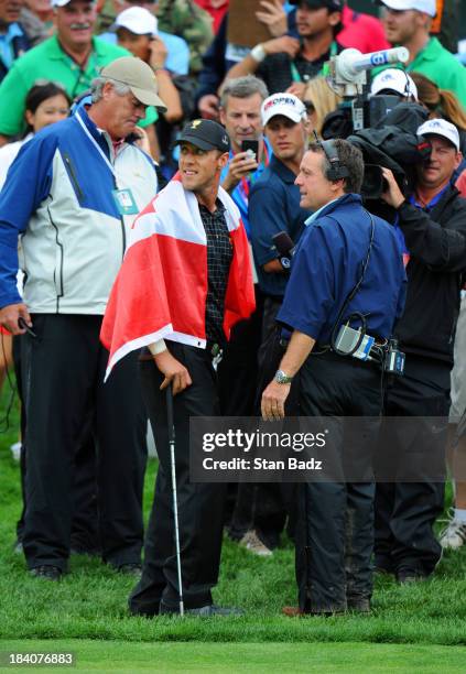 Graham DeLaet of the International Team turns to watch play on the 18th green during the final round of The Presidents Cup at Muirfield Village Golf...