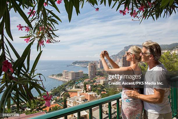 couple take picture over city and sea from balcony - montecarlo stock pictures, royalty-free photos & images