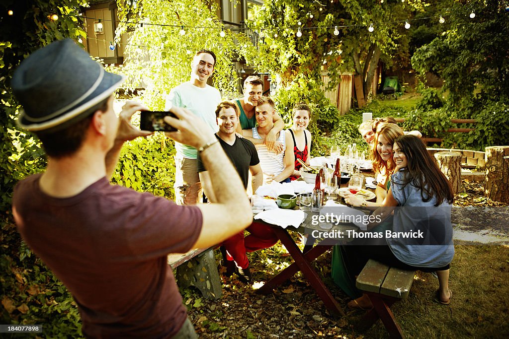 Man taking photo of friends with smart phone