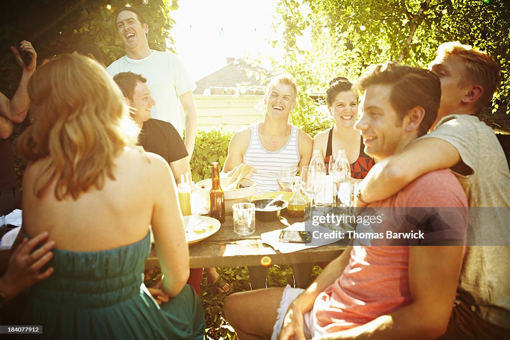 Group of friends sitting at table in backyard