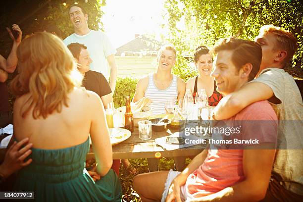 Group of friends sitting at table in backyard