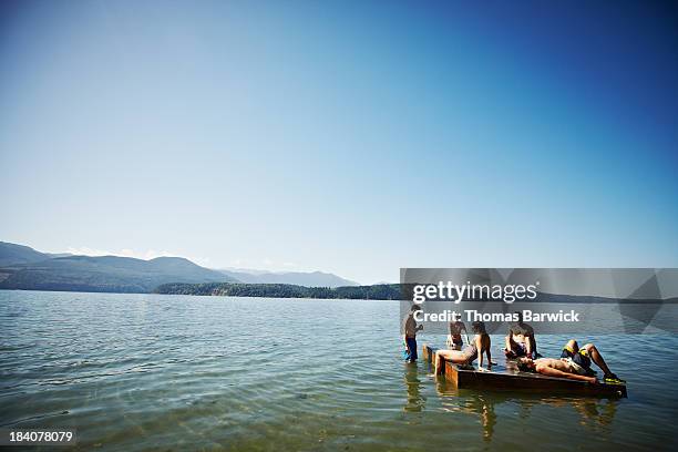 group of friends hanging out on floating dock - diving platform fotografías e imágenes de stock