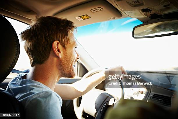 smiling man driving car - guidare foto e immagini stock