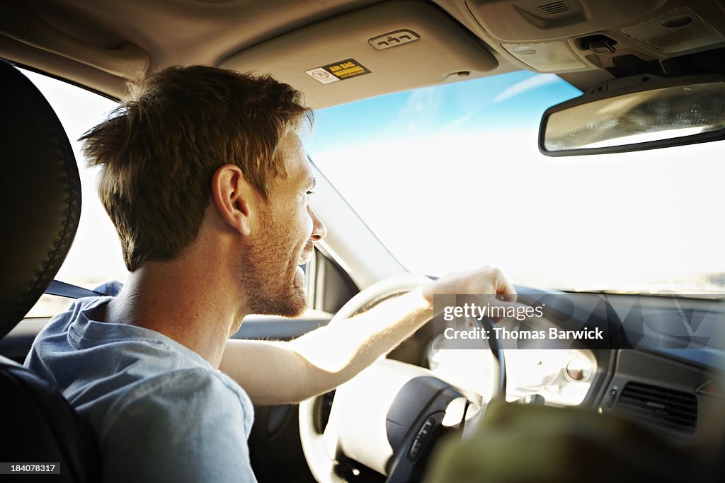 Smiling man driving car