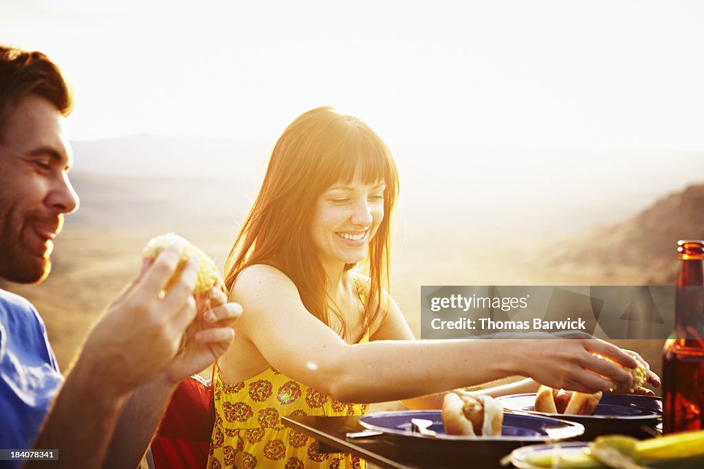 Smiling couple dining at table at sunset