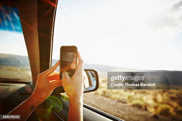 woman riding in car taking photo with smartphone - car photo shoot stock pictures, royalty-free photos & images