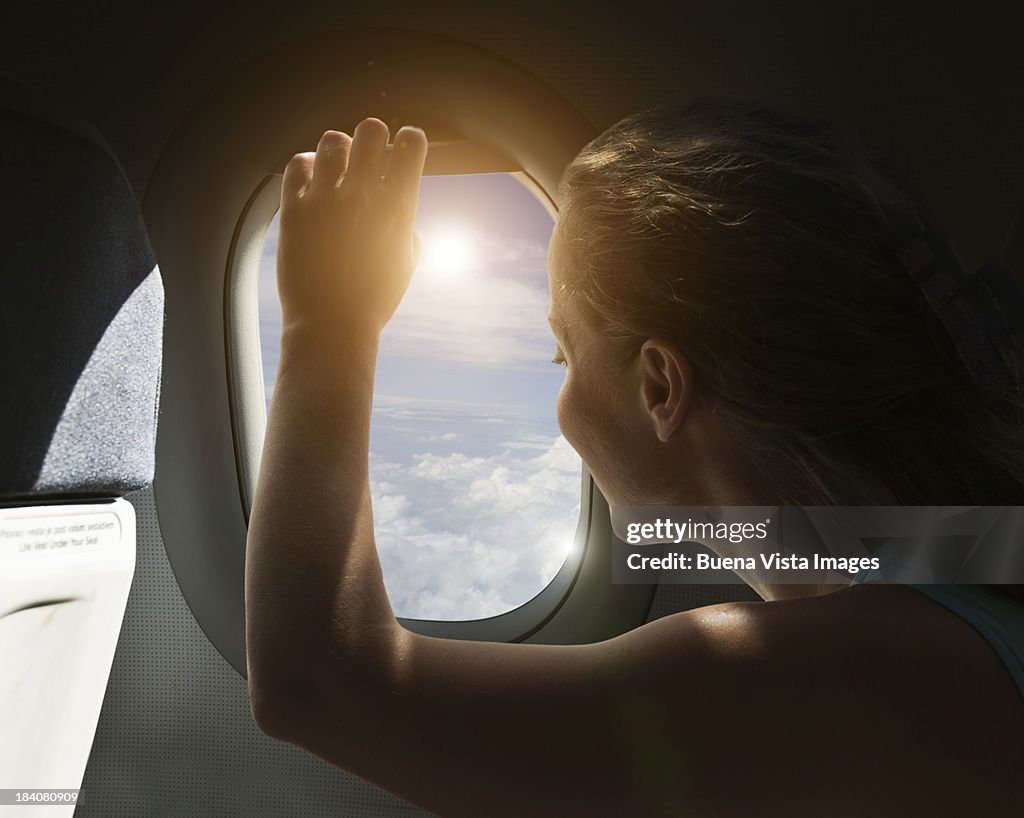 Woman watching sky from airplane's window.