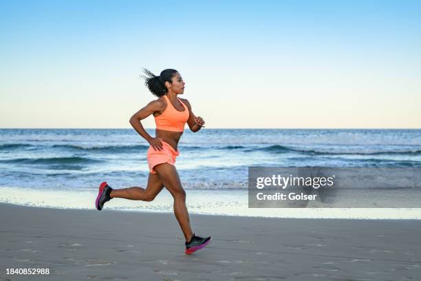 woman doing sports training drill on the beach - runner stock pictures, royalty-free photos & images