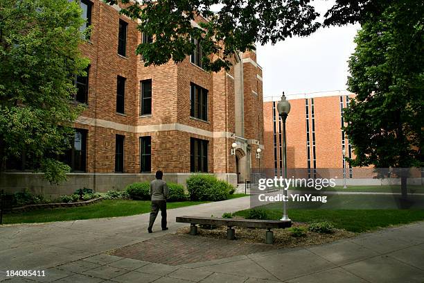 student walking toward university campus school buildings for education, learning - brick pathway stock pictures, royalty-free photos & images